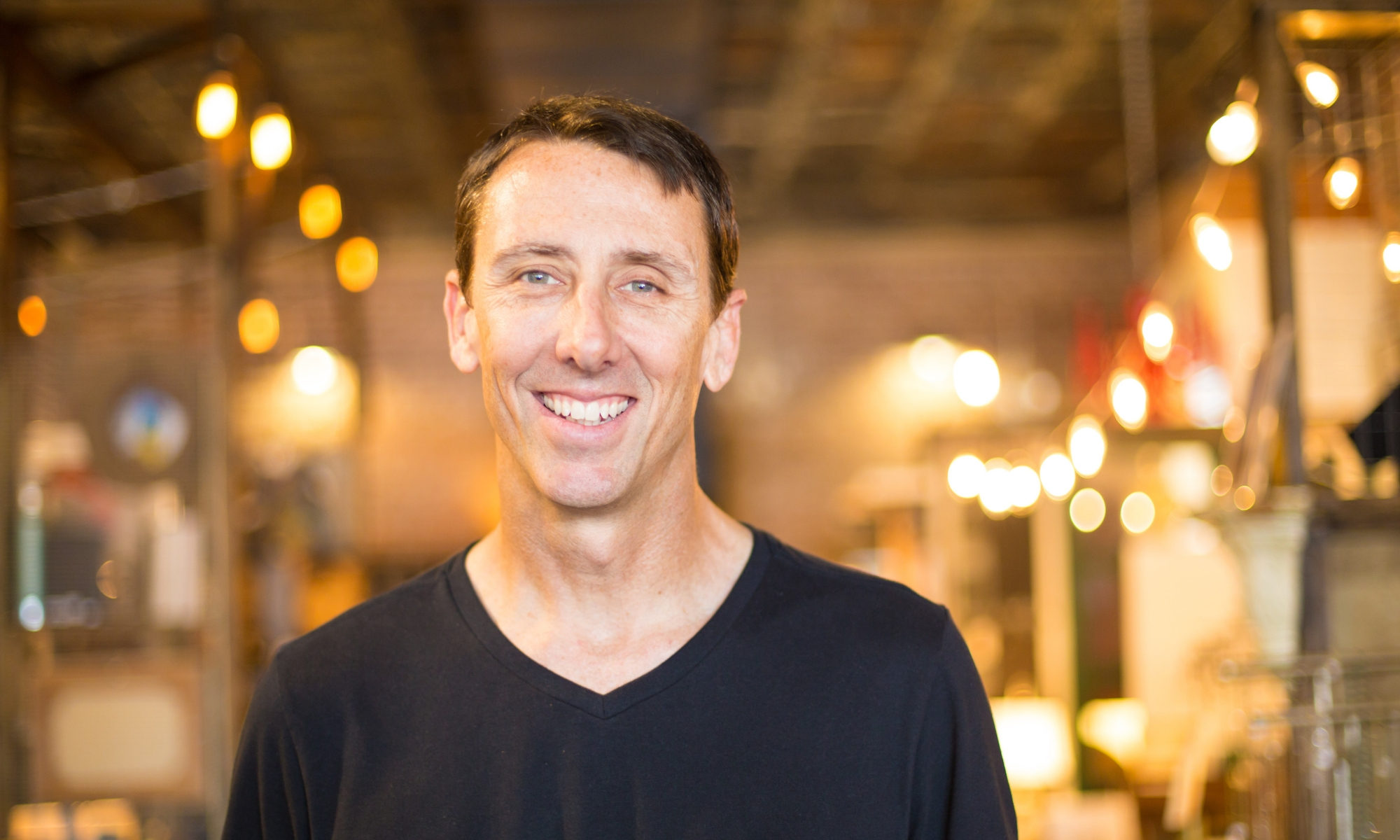 Shannon Pilcher smiles in front of beautifully lit store