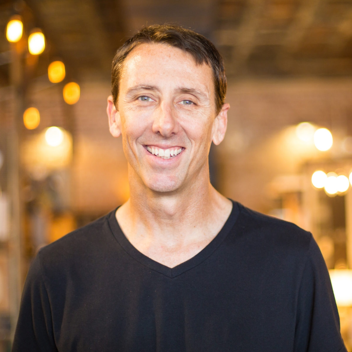 Shannon Pilcher smiles in front of beautifully lit store