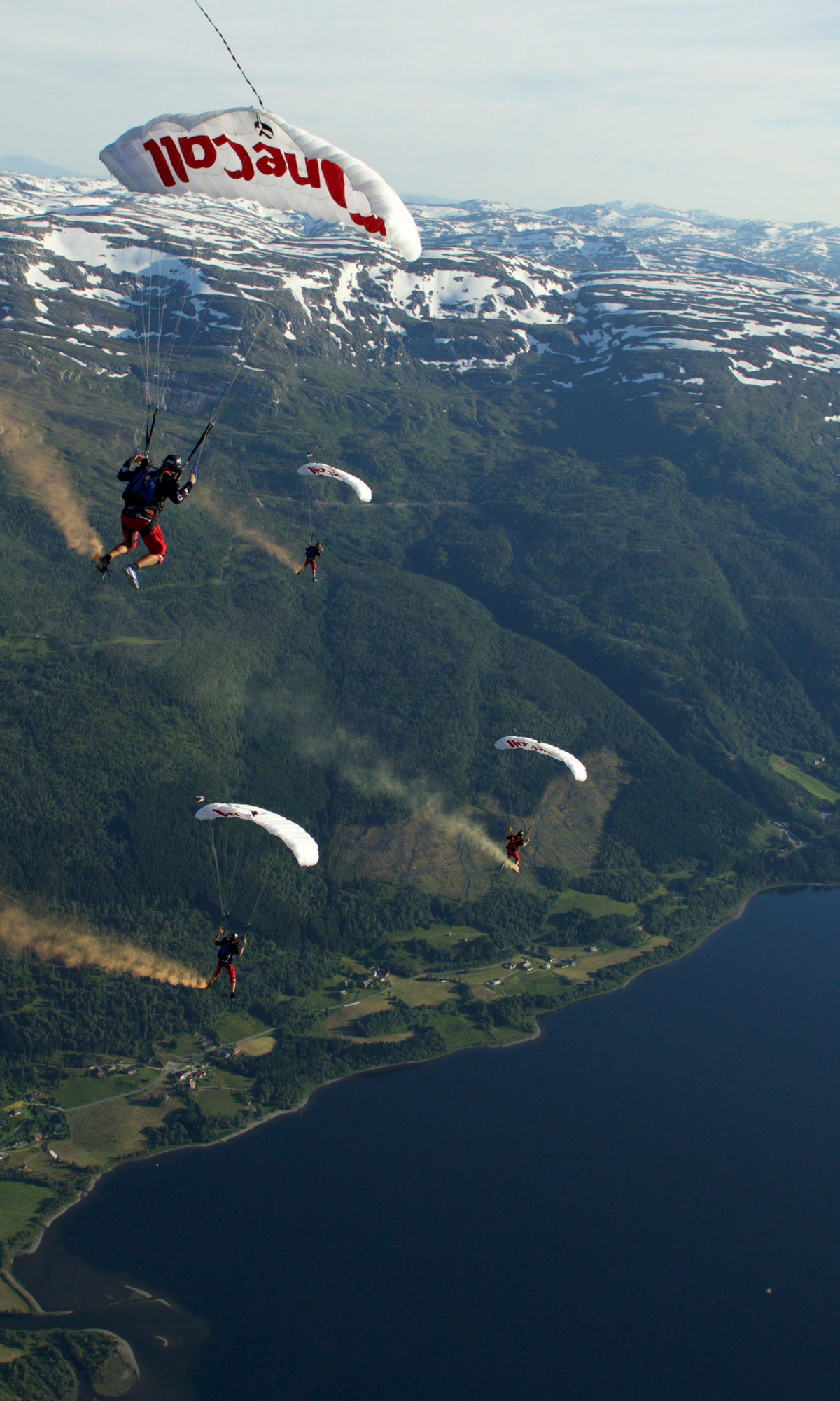 Shannon Pilcher under canopy with PD Factory team with a view of snowy mountains and beautiful lake