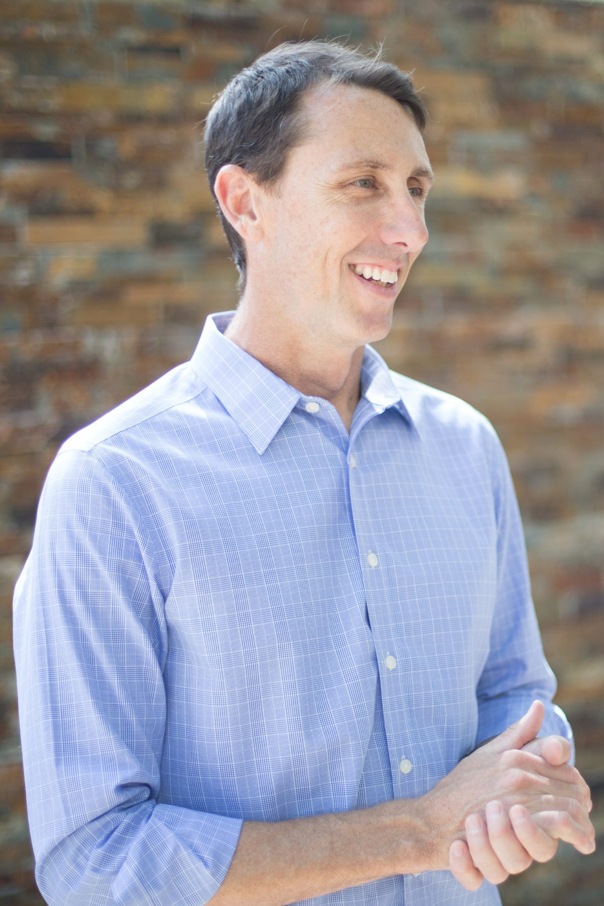 Shannon Pilcher stands in front of brick with hands clasped